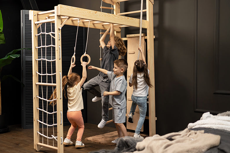Fröhliche Kinder klettern und hangeln spielerisch an der Kletterwand