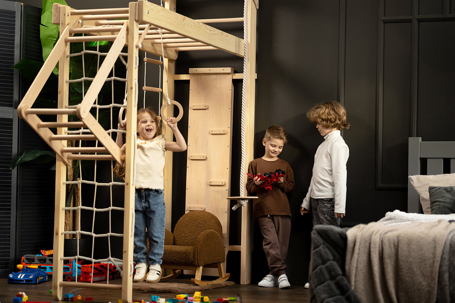 Drei Kinder spielen gemeinsam aktiv an der BeLissi Nelo Kletterwand